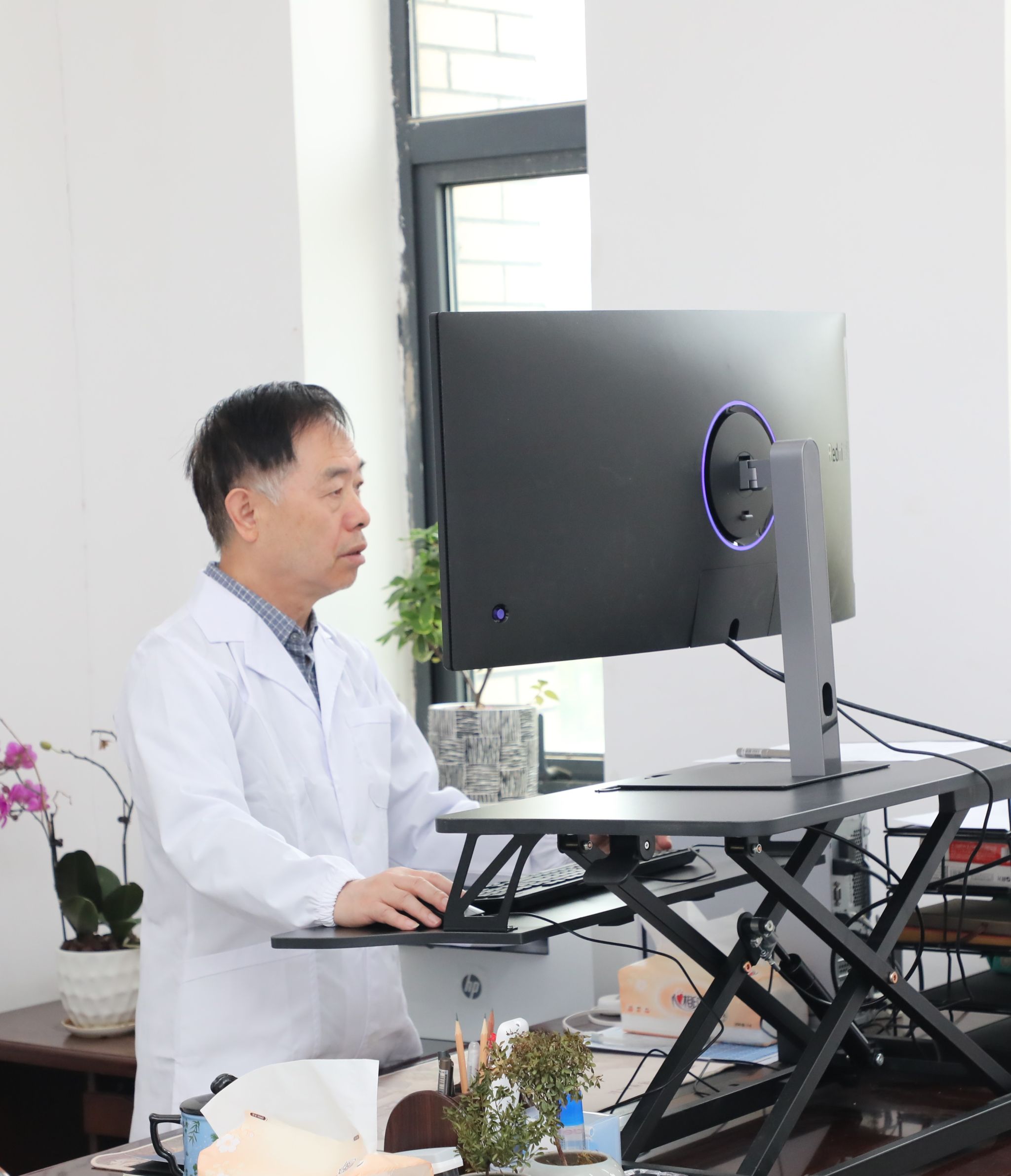 腰椎不好,武汉大学帮扶yl23455永利集团生物学学科领队孙蒙祥教授站着办公。薄文鹤 摄